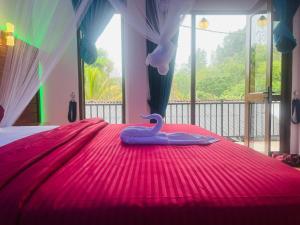 un lit rose avec un cygne en plastique dessus dans l'établissement Ella EDAN Homestay, à Ella 3 autres photos