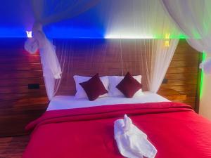 une chambre avec un lit rouge avec des draps et des rideaux rouges dans l'établissement Ella EDAN Homestay, à Ella
