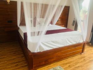 - une chambre dotée d'un lit avec des rideaux dans l'établissement Ella EDAN Homestay, à Ella