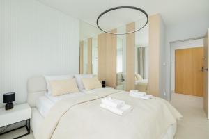 ein Schlafzimmer mit einem weißen Bett mit zwei Handtüchern darauf in der Unterkunft Apartment Sea Light - Best Comfort - by rentmonkey in Pogorzelica