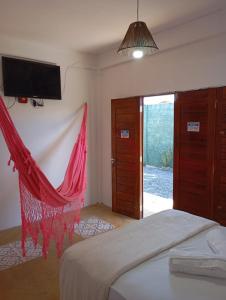 a bedroom with a bed with a red net at Pousada Paraíso das Dunas in Barroquinha +21 photos