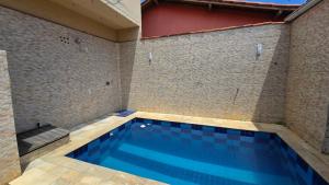 a swimming pool in a room with a tile wall at Casa com Piscina Peró in Cabo Frio