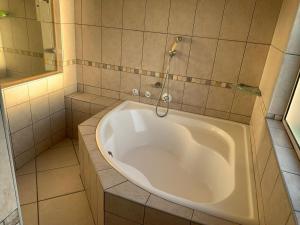 e bagno con vasca e doccia. di Florida Cloud 9 a Roodepoort