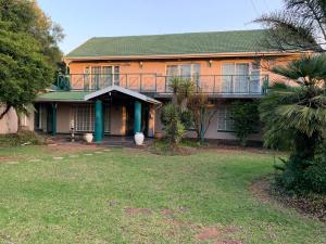 una casa arancione con balcone e cortile di Florida Cloud 9 a Roodepoort