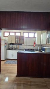 a large kitchen with wooden cabinets and a counter top at Casa com Piscina Peró in Cabo Frio