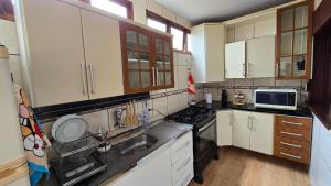 a kitchen with a sink and a stove top oven at Casa com Piscina Peró in Cabo Frio