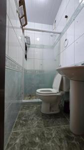a bathroom with a toilet and a sink at Casa com Piscina Peró in Cabo Frio +17 photos