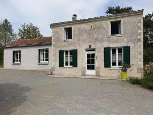 ein altes Steinhaus mit grünen Fensterläden in der Unterkunft Gîte du Tilleul - un petit coin de nature in Vallet