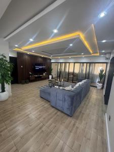 uma grande sala de estar com um grande sofá azul em Top Loft 3bed Penthouse em Lagos mais 74 fotografias