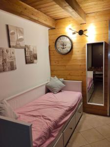 a bedroom with a bed and a clock on the wall at Casa Meli in Passo del Tonale