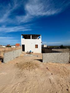 a building in the middle of a dirt field at Por Do Sol Residence in Canoa Quebrada