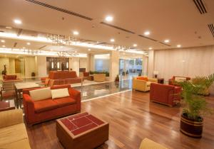 a large lobby with couches and tables and chairs at Dolphin Hotel in Visakhapatnam