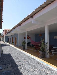 a patio of a house with a hammock under it at Pousada Paraíso das Dunas in Barroquinha