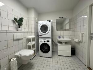 a bathroom with a washing machine and a washer at Anacoco Suites in Würselen