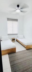 two beds in a room with a ceiling fan at HomestayFA in Gua Sai
