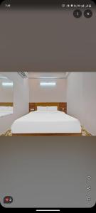 a bed in a room with a white bedvisor at Hotel Grande Inn in Udaipur