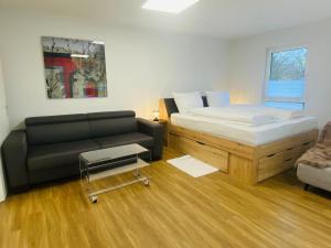 a bedroom with a bed and a couch at Anacoco Suites in Würselen
