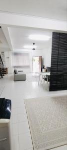 a white living room with a couch and a table at HomestayFA in Gua Sai