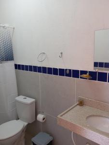 a bathroom with a toilet and a sink and a mirror at Pousada Paraíso das Dunas in Barroquinha
