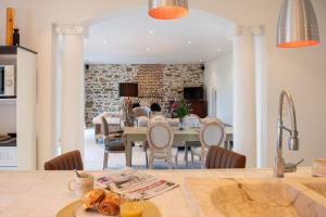 a kitchen and dining room with a table and chairs at La Forge Maison de 110m2 en Limousin in Coussac-Bonneval