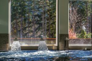 a pool of water in a building with a fountain at Maison Poluc - Petit Bijou in Champoluc