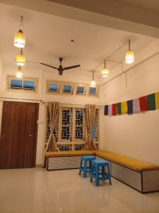 ein Wohnzimmer mit einer Bank und 2 blauen Stühlen in der Unterkunft Tribal Hostel & Homestay in Guwahati