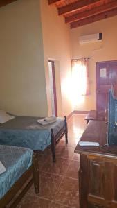 a room with two beds and a desk with a computer at Hosteria LA VIEJA CARRETA in Purmamarca