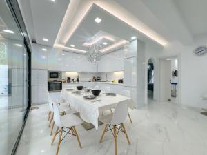 eine Küche und ein Esszimmer mit einem weißen Tisch und Stühlen in der Unterkunft Diamond Luxury Villa Corfu in Káto Spílaion