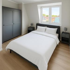 a large white bed in a bedroom with two windows at Twenty2 Apartments in Brühl +22 photos
