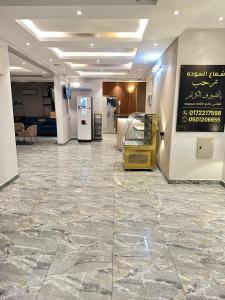una hall con un grande pavimento piastrellato e un cartello su un muro di شقق شعاع السوداء a Abha