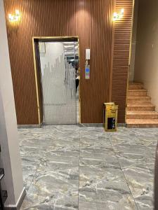 una hall con una porta a vetri attraverso la quale passa una persona di شقق شعاع السوداء a Abha