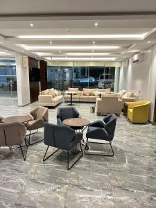 una hall con divani, tavoli e sedie in un edificio di شقق شعاع السوداء a Abha