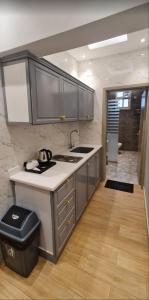 una cucina con lavandino e bancone con bidone della spazzatura di شقق شعاع السوداء a Abha