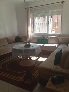 Oulad KerroumPeace of mind的客厅里有一张桌子和一张沙发 更多1张照片