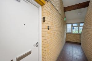 einen Flur mit Ziegelwand und Tür in der Unterkunft The Randolph 2-Bed MK9 Flat Short- Long-Stay Family & Contractor Friendly Free Parking close to Theatre, Now with lounge in Milton Keynes + 21 Fotos