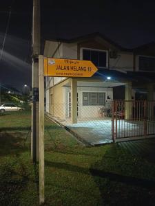 a sign in front of a house at night at HomestayFA in Gua Sai