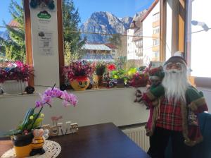 a santa claus figurine standing in front of a window at Little Bear Busteni 3 in Buşteni +45 photos