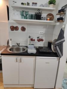 a small kitchen with white cabinets and a sink at Isi beauty in Jagodina