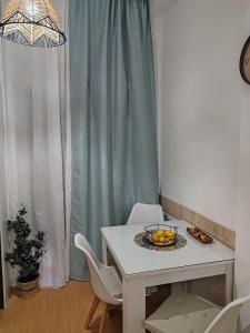 a white table with a bowl of fruit on it at Isi beauty in Jagodina