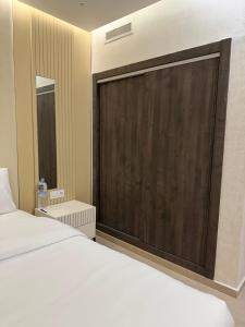 a bedroom with a large bed and a wooden door at Apartment City Center Hilton Tanger in Tangier