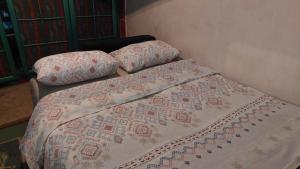 a bed with a comforter and pillows on it at Apartmani Bogatić in Bogatić