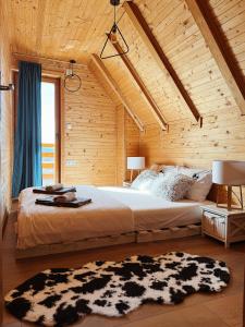 a bedroom with a large bed in a wooden wall at Casa Mia Resort in Kupres