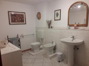 a bathroom with a sink and a toilet and a mirror at Villa Bella bed and breakfast in Favale di Malvaro