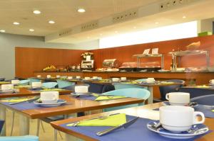 a restaurant with tables and chairs with cups on them at Hotel Murrieta in Logroño