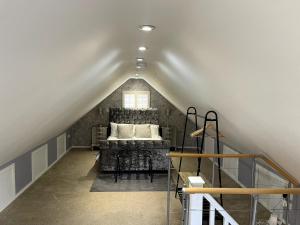 a attic room with a bed and a window at Greenfinch Lodge in Norton Heath