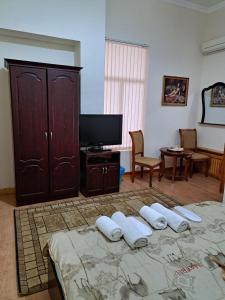 una camera da letto con un letto con una tv e un tvicterictericter di Hotel Latif Samarkand a Samarkand Altre 106 foto