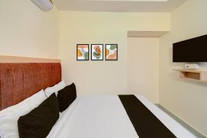 a bedroom with a bed and a flat screen tv at Hotel O RR Grand Luxury Rooms in Upal