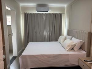 伊瓜苏Ravello Residencial - Próximo ao Paraguai e Centro de Foz do Iguaçu的卧室里有一张床，床单和枕头都是白色的