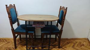 a wooden table and two chairs with blue seats at hometown in Pančevo