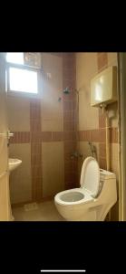 Un baño con inodoro blanco y ventana. en غرفة بدورة مياة بدخول ذاتي, en Al Kharj